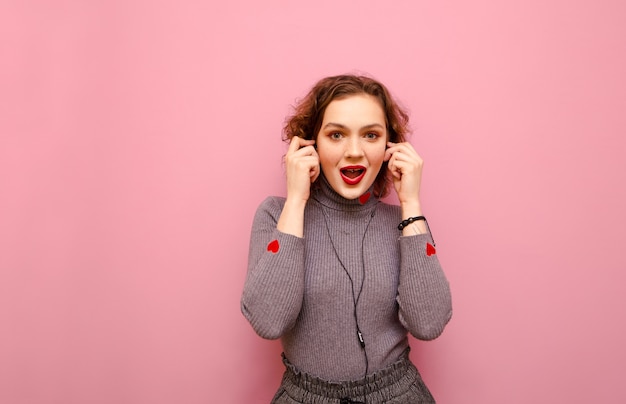 Portret van gelukkige mooie dame in grijze trui en krullend haar