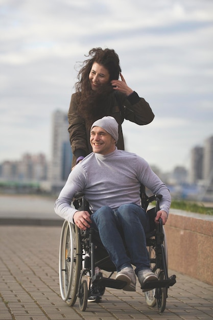 Portret van gelukkige paar zorgzame vrouw met gehandicapte man in rolstoel