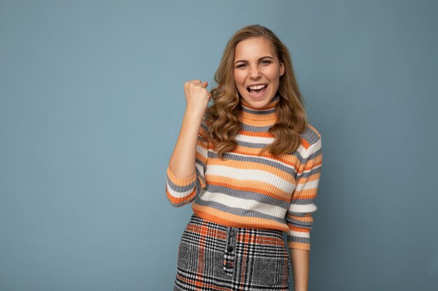 Portret van gelukkige positieve jonge aantrekkelijke blonde krullende vrouw met oprechte emoties trendy dragen