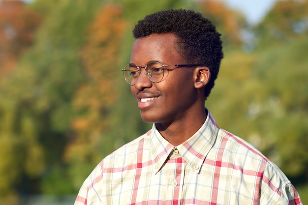 Portret van gelukkige positieve zwarte Afrikaanse man Afro-Amerikaanse etnische jonge kerel in glazen shirt is