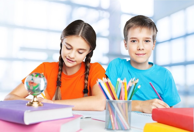 Portret van gelukkige schoolkinderen die tekenen met kleurpotloden