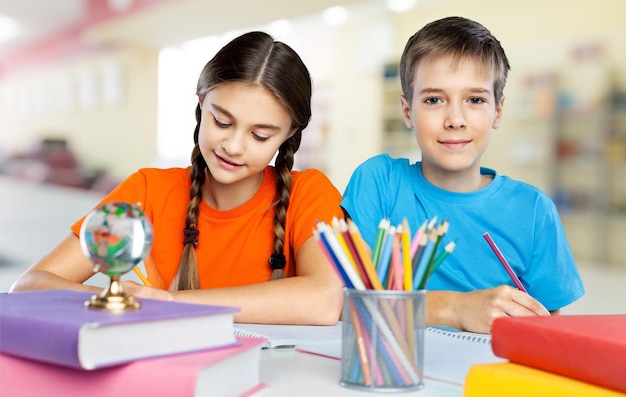 Portret van gelukkige schoolkinderen die tekenen met kleurpotloden