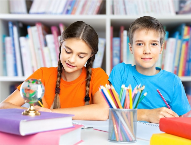 Portret van gelukkige schoolkinderen die tekenen met kleurpotloden