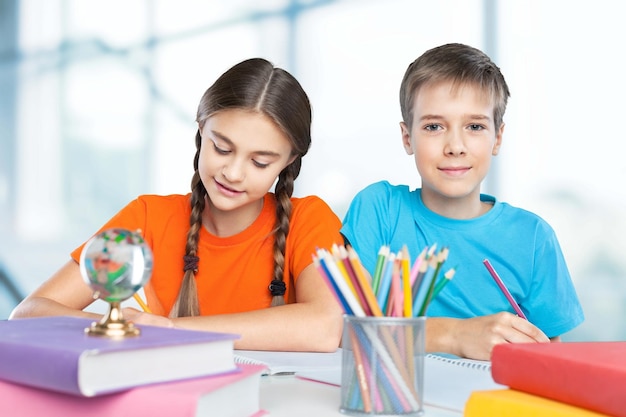 Portret van gelukkige schoolkinderen die tekenen met kleurpotloden
