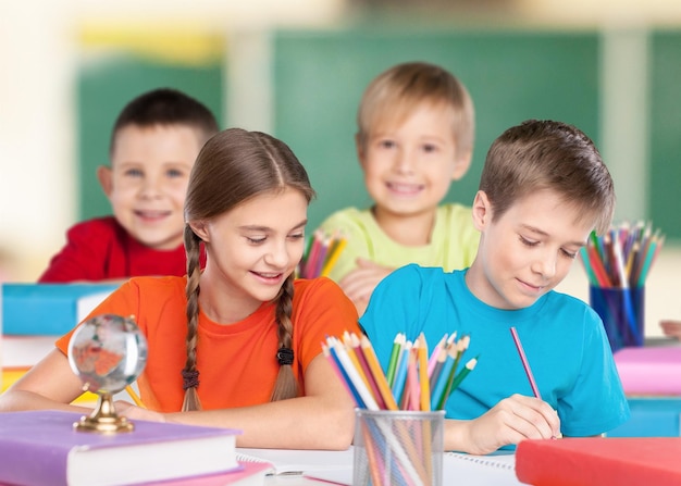 Portret van gelukkige schoolkinderen die tekenen met kleurpotloden