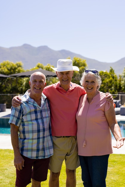 Portret van gelukkige senior diverse mensen omarmen en glimlachen in de tuin