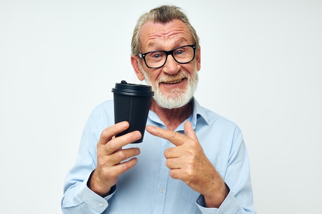 Portret van gelukkige senior man gebaren met zijn handen een glas drank geïsoleerde achtergrond