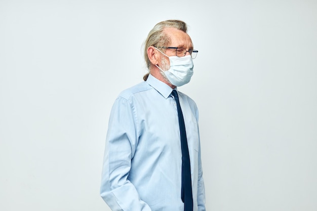 Portret van gelukkige senior man medische veiligheidsmasker gezondheid lichte achtergrond