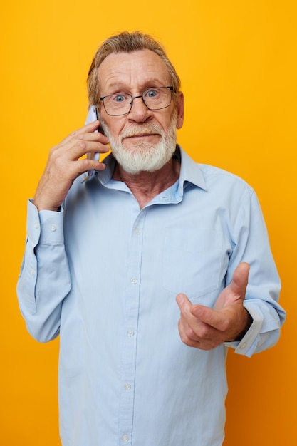 Portret van gelukkige senior man praten aan de telefoon emoties geïsoleerde achtergrond