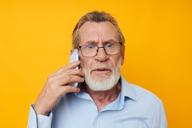 Portret van gelukkige senior man praten aan de telefoon poseren close-up geïsoleerde background