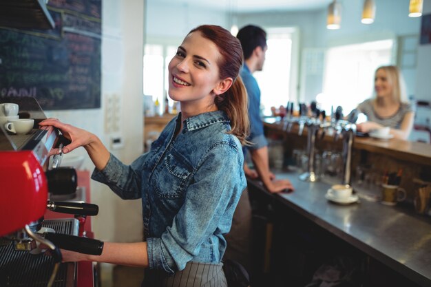 Portret van gelukkige serveerster met medewerker die aan klant bij koffiewinkel spreken