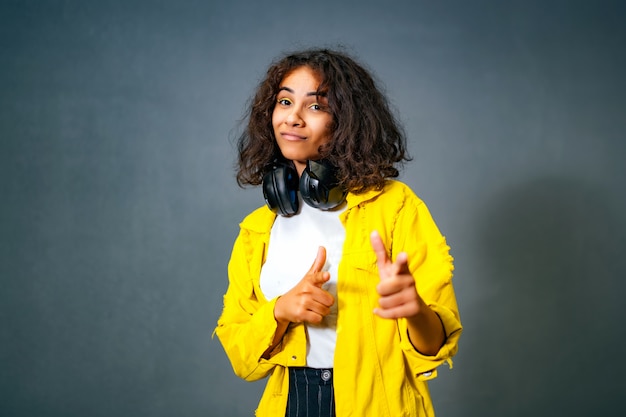 Portret van gelukkige tiener met hoofdtelefoons het stellen