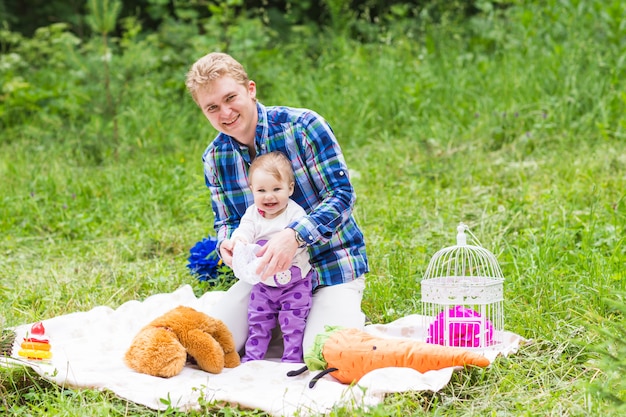 Portret van gelukkige vader met dochter in zomerpark.