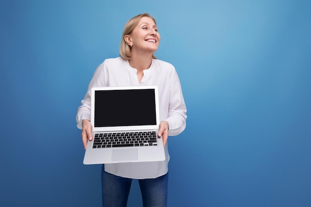 Portret van gelukkige volwassen zakenvrouw met blond haar met laptop met schermsjabloon