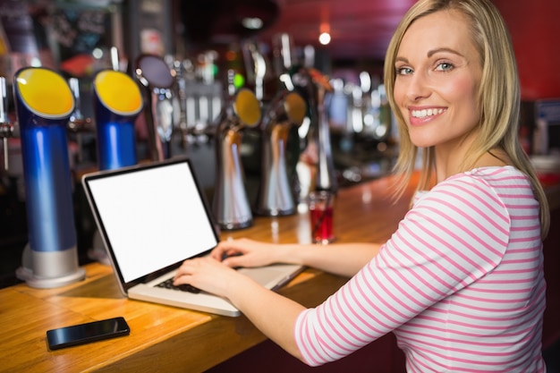 Portret van gelukkige vrouw met behulp van de laptop