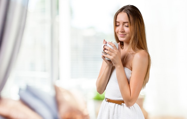 Portret van gelukkige vrouw met mok in handen