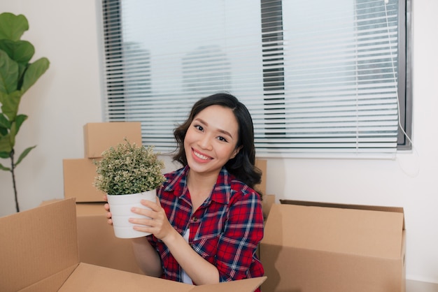 Portret van gelukkige vrouw tijdens verhuizing met kartonnen dozen