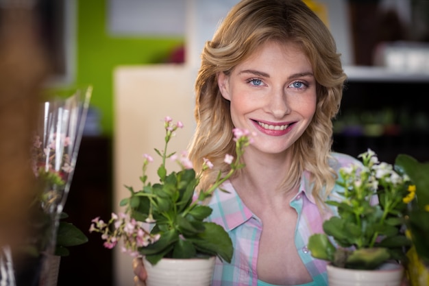 Portret van gelukkige vrouwelijke bloemist met bloempot