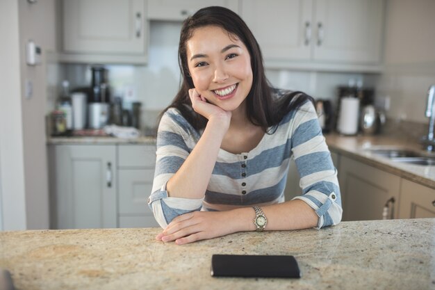 Portret van gelukkige vrouwenzitting in keuken