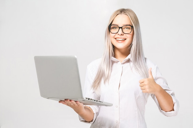 Portret van gelukkige wow jonge mooie glimlachende vrouw die zich met laptop bevindt die op witte achtergrond wordt geïsoleerd