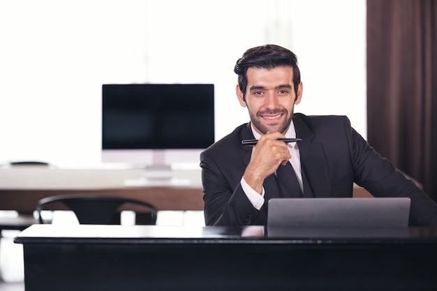 Portret van gelukkige zakenman achter bureau