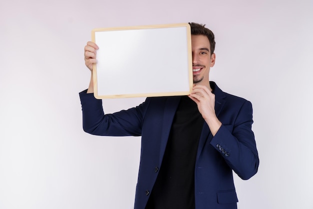 Portret van gelukkige zakenman die leeg uithangbord op geïsoleerde witte achtergrond toont