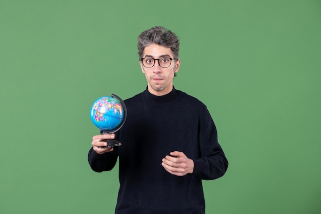 portret van geniale man met kleine aardbol studio-opname groene achtergrond natuur planeet ruimte