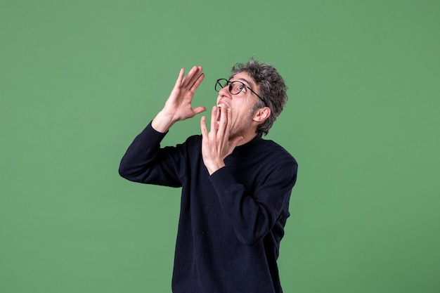 Foto portret van geniale man terloops gekleed in studio-opname wijzend op groene muur