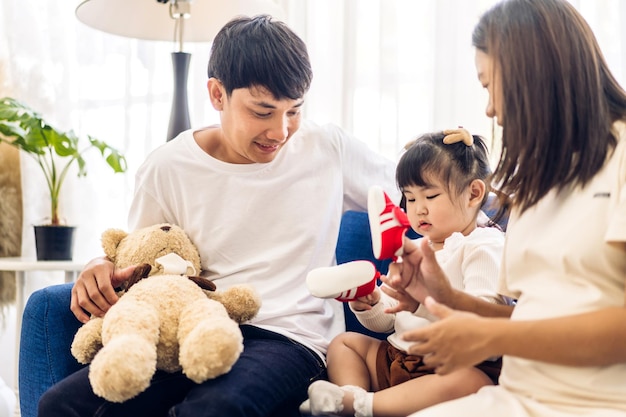 Portret van genieten van gelukkige liefde aziatische familie vader en moeder die knuffel schattig klein aziatisch meisje kind glimlachend spelen en leuke momenten thuis hebben