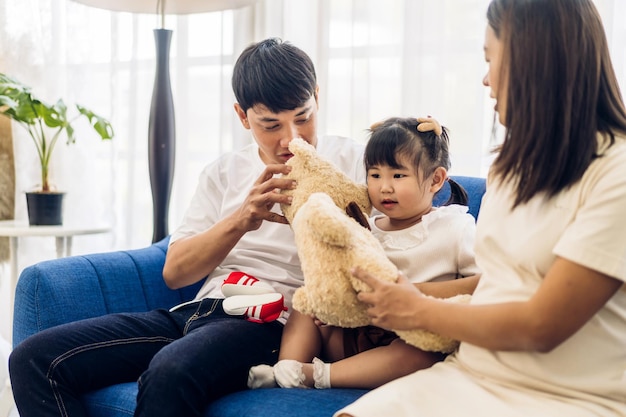 Portret van genieten van gelukkige liefde aziatische familie vader en moeder die knuffel schattig klein aziatisch meisje kind glimlachend spelen en leuke momenten thuis hebben