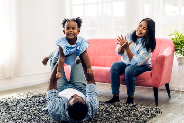 Portret van genieten van gelukkige liefde zwarte familie afro-amerikaanse vader en moeder met een klein afrikaans meisje dat lacht en speelt met leuke momenten goede tijd in de kamer thuis