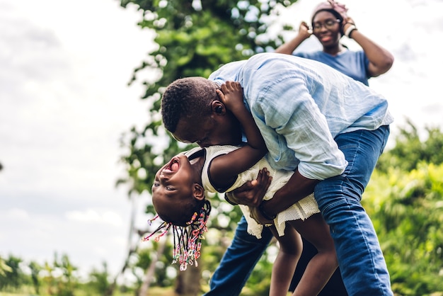 Portret van genieten van gelukkige liefde zwarte familie afro-amerikaanse vader en moeder met klein afrikaans meisje kind glimlachend en plezier momenten goede tijd