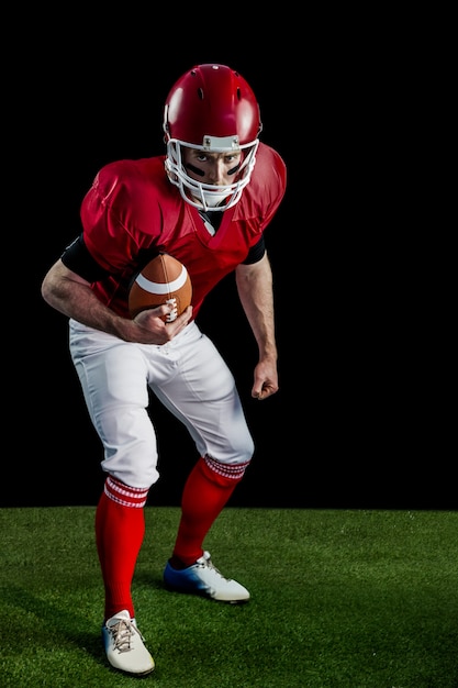 Portret van gerichte Amerikaanse voetballer klaar om aan te vallen