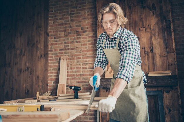 Portret van gerichte bebaarde vakman poseren in zijn woodshop