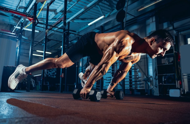 Portret van gespierde atleet, bodybuilder workouts alleen op sport sportschool, binnenshuis.