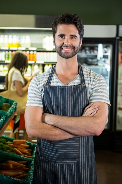 Portret van glimlachend mannelijk personeel die zich met wapens bevinden die in organische sectie worden gekruist