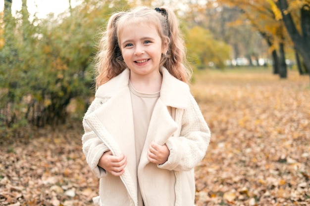 portret van glimlachend mooi meisje in stijlvolle kleding in de natuur in het herfstpark