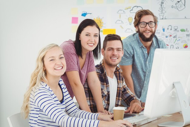 Portret van glimlachende bedrijfsberoeps die bij computerbureau werken