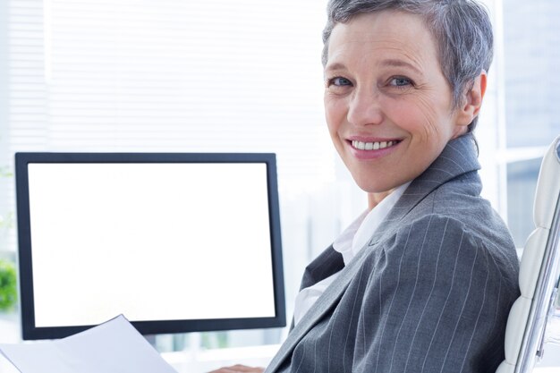 Portret van glimlachende businsswoman die computer met behulp van