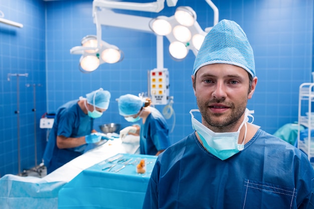Portret van glimlachende chirurg in verrichtingsruimte