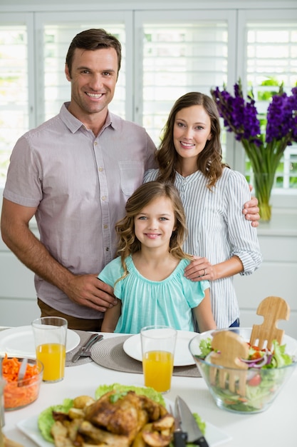 Portret van glimlachende familie die lunch samen op eettafel hebben