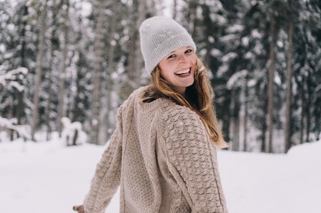Portret van glimlachende jonge vrouw die in de sneeuw staat
