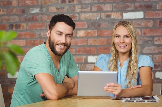 Portret van glimlachende man en vrouw met digitale tablet