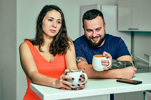 Foto portret van glimlachende moeder en dochter die op tafel zitten