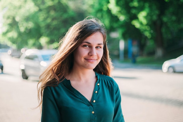 Foto portret van glimlachende mooie vrouw op straat tegen bomen