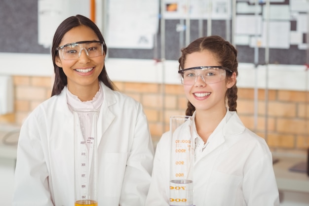 Portret van glimlachende schoolmeisjes die zich in laboratorium bevinden