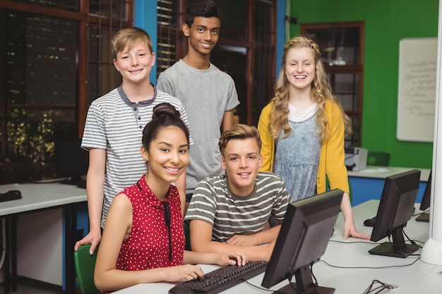 Portret van glimlachende studenten die in computerlokaal studeren