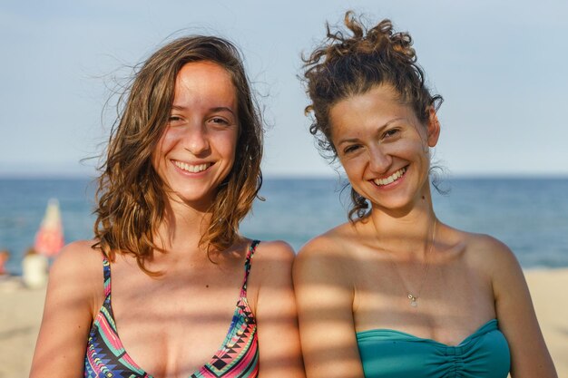 Foto portret van glimlachende vrienden op het strand