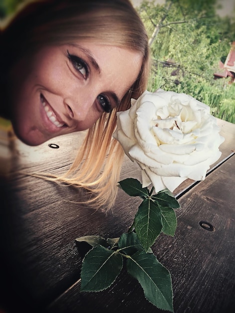 Foto portret van glimlachende vrouw bij witte bloem