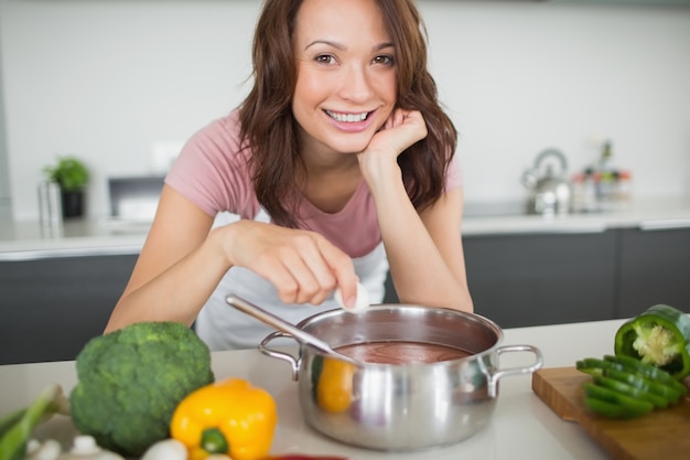 Portret van glimlachende vrouw die voedsel in keuken voorbereidt